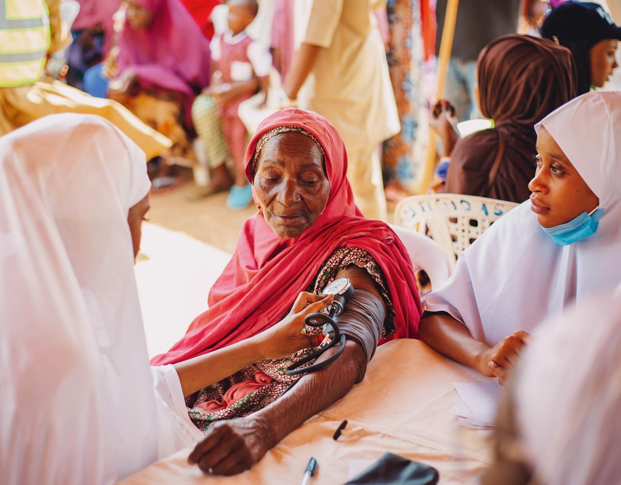 Crafting Captivating Headlines: Your awesome post title goes here An outdoor health checkup for the elderly in Kaduna, Nigeria, emphasizing community care.